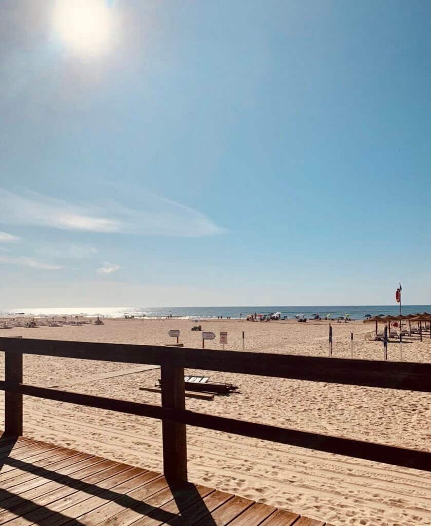 Zonovergoten strand met houten terras en uitzicht op de oceaan, ideaal voor ontspanning en genieten.