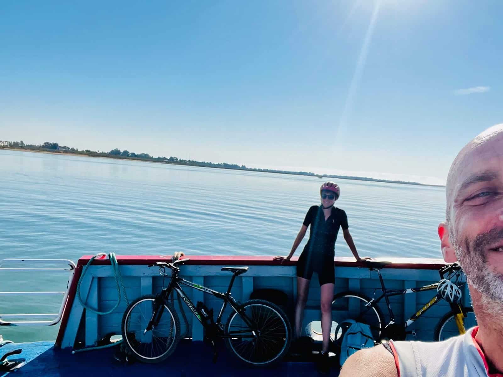 Fietsen op een rivierboot met uitzicht op water en blauwe lucht.